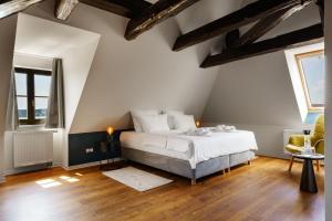 um quarto com uma cama branca e 2 janelas em Hotel Waren-Alte Warener Zeitung em Waren