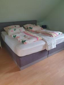 Una cama con sábanas blancas y almohadas. en Feriendomizil Meeresnah, en Hage