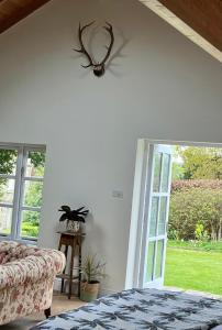 a living room with a couch and a sliding glass door at The Billiard Room - Cosy Country Retreat in Abergavenny