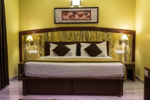 een slaapkamer met een groot bed met een houten hoofdeinde bij Hotel Chennai Gate in Chennai