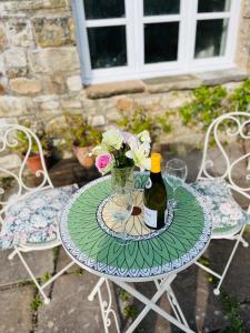 uma mesa com uma garrafa de vinho e flores em The Billiard Room - Cosy Country Retreat em Abergavenny