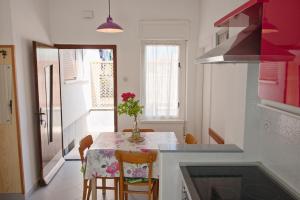 a kitchen with a table with a vase of flowers on it at Apartments Vili in Umag