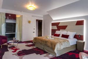 a hotel room with a large bed with a striped wall at Domaine de La Ferrière in Châteaubriant