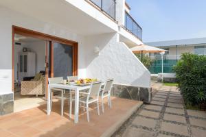 einen weißen Tisch und Stühle auf einer Terrasse in der Unterkunft Bonito bungalow con piscina junto a la playa in San Bartolomé de Tirajana