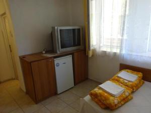 a room with a tv on a cabinet and a bed at Hrisi in Chernomorets