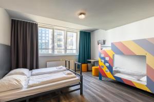 a bedroom with a bed and a colorful wall at a&o Wien Hauptbahnhof in Vienna
