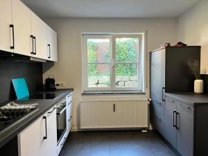 een keuken met een koelkast en een raam bij Lo Ferienwohnung in Friedrichshafen