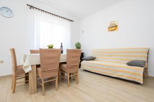 a dining room with a table and chairs and a bed at Apartment Andjelko G in Šilo