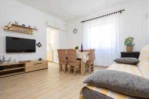 a living room with a dining table and a television at Apartment Andjelko G in Šilo