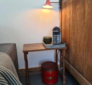 een kleine tafel met een radio erop naast een bed bij Studio tussen de bossen en de bollenvelden in Noordwijkerhout