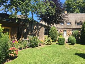 un jardin devant une maison avec des fleurs dans l'établissement Kreatives Wohnen unter Reet ruhig und doch zentral, à Schwabstedt