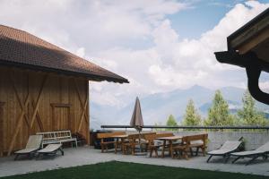a patio with tables and chairs and a view of mountains at Apartments Oberpichlhof in Valdaora