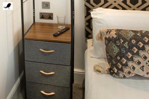a bedroom with a bed and a dresser with a remote control at Blackbird Accommodation and Luxury Apartments room 14 in Blackpool