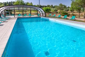 uma grande piscina com cadeiras azuis num resort em Hotel Vilar Rural d'Arnes by Serhs Hotels em Arnes