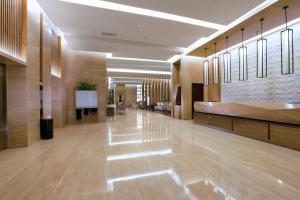 eine große Lobby mit Holzböden und einem großen Saal in der Unterkunft ASTON Banua Banjarmasin Hotel & Convention Center in Banjarmasin