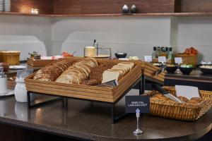 コペンハーゲンにあるホテル サンクト トーマスのテーブルの上にパンとバスケットを並べる