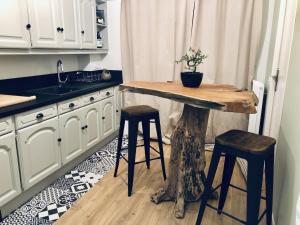 eine Küche mit einem Holztisch und 2 Hockern in der Unterkunft Appartement face à la mer in Santa-Maria-di-Lota