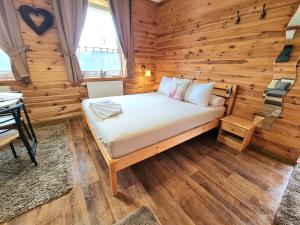 1 dormitorio con 1 cama en una habitación de madera en Éden Vendégház, en Aggtelek