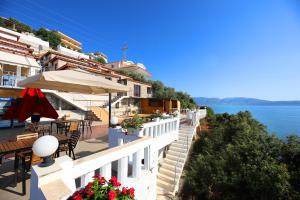un patio con tavoli, ombrellone e acqua di Seascape Villas a Vlorë
