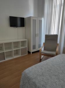 una camera con letto, sedia e televisore di Lira Guest House B&B a Porto Altre 39 foto