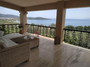 - un salon avec un balcon offrant une vue sur l'océan dans l'établissement Infinite View, à Ancient Epidavros