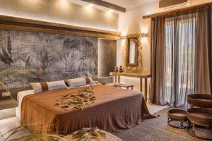 a bedroom with a large bed with a large painting on the wall at Avithos Resort Hotel in Svoronata