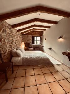 a bedroom with a bed and a stone wall at The Stone Boat Guesthouse for Pilgrims in Rabanal del Camino