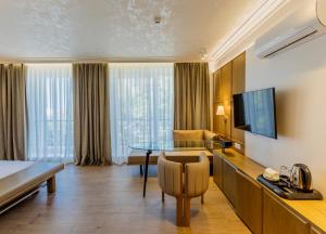 a hotel room with a dining table and a television at Sea Breeze Resort&Residence in Baku