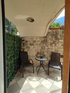 a patio with two chairs and a table at Studio Apartman Radimir in Kotor