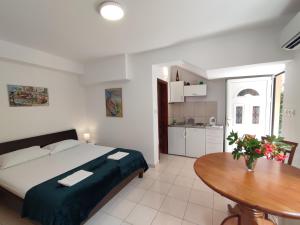 a bedroom with a bed and a wooden table at Studio Apartman Radimir in Kotor