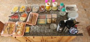 an overhead view of a counter with many food items at Pousada e Restaurante Império do Marisco in Maragogi