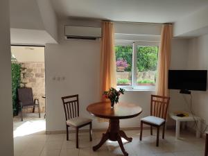 a dining room with a table and chairs and a window at Studio Apartman Radimir in Kotor +1 photo