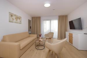 ein Wohnzimmer mit einem Sofa und einem TV in der Unterkunft Yourapartment Theresien in Wien