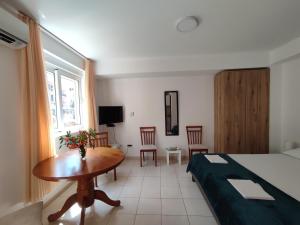 a hotel room with a bed and a table and chairs at Studio Apartman Radimir in Kotor