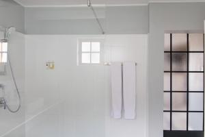 a white bathroom with a shower and windows at Beausoleil in Bonnievale +58 photos