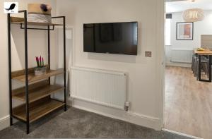 a living room with a flat screen tv on a wall at Blackbird Accommodation and Luxury Apartments room 15 in Blackpool
