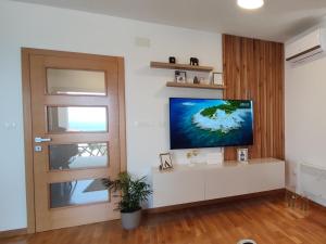 a living room with a flat screen tv on a wall at Holiday House Lucy in Pakoštane