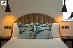 ein Schlafzimmer mit einem großen Bett mit blauen und weißen Kissen in der Unterkunft Blackbird Accommodation and Luxury Apartments room 15 in Blackpool