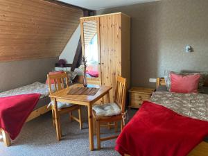 a bedroom with two beds and a table and a desk at Haus Mohnke in Hiddensee