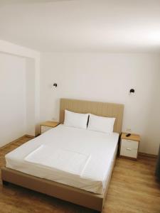 una camera da letto con un grande letto con lenzuola bianche di Vila Eric a Eforie Sud