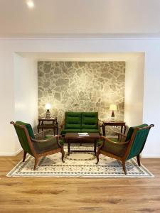 a living room with two chairs and a green couch at Villa Alter in Alter do Chão
