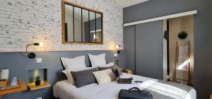 a bedroom with a large bed with a mirror on the wall at Hôtel Le C - Boutique Hôtel in Narbonne