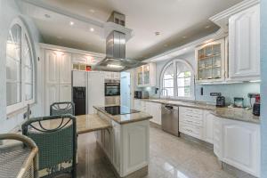 a kitchen with white cabinets and a counter top at Gorgeous Golf Villa Heated Pool Sea view in Adeje