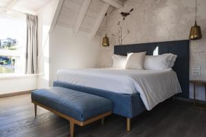 um quarto com uma cama grande e um banco azul em LUXURY SUITES ROCOPOM - Lake Front em Lecco