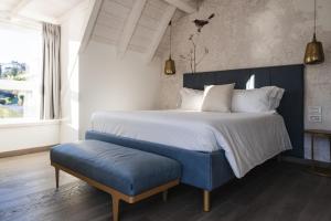 レッコにあるLUXURY SUITES ROCOPOM - Lake Frontのベッドルーム(大型ベッド1台、青いベンチ付)