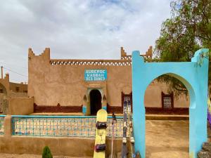 a building with a blue gate and a swimming pool at Auberge Kasbah Des Dunes in Merzouga