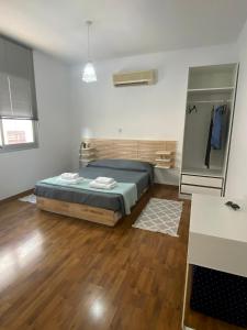 a bedroom with a bed and a wooden floor at Lovely studio apartment in Pafos in Paphos City