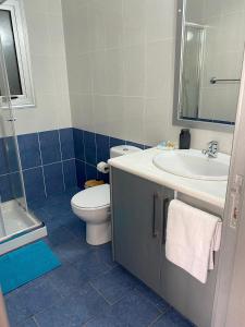 a bathroom with a sink and a toilet and a mirror at Lovely studio apartment in Pafos in Paphos