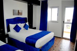 - une chambre avec un lit bleu et blanc et une fenêtre dans l'établissement Hotel Al Khaima, à Assilah