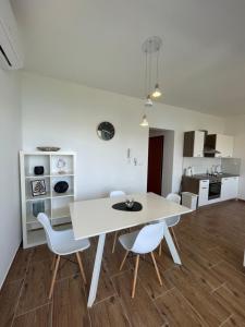 a white dining room with a white table and chairs at A&A Apartments by the sea in Trogir